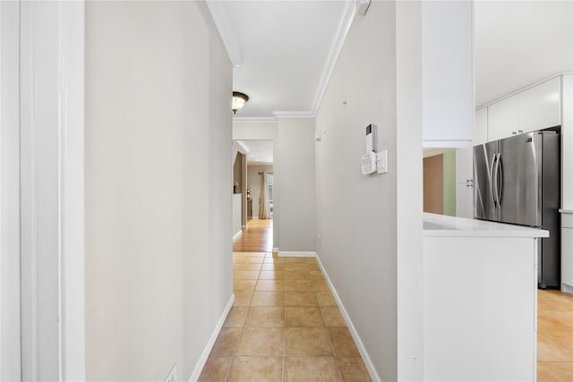 hallway with crown molding and light tile patterned flooring