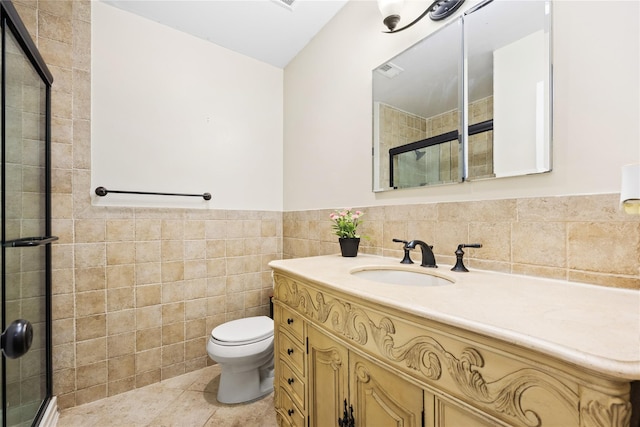 bathroom with an enclosed shower, tile patterned floors, tile walls, toilet, and vanity