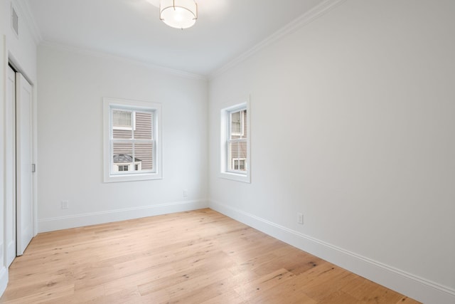 unfurnished bedroom with light wood-type flooring, visible vents, baseboards, and crown molding