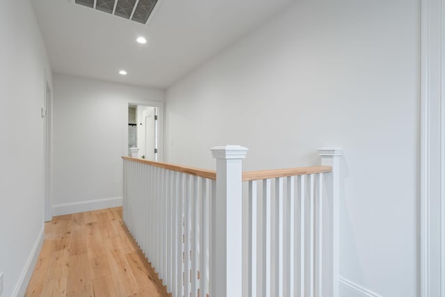 corridor with light wood-style flooring, visible vents, baseboards, and recessed lighting