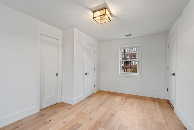 unfurnished bedroom with light wood-style floors, visible vents, and baseboards