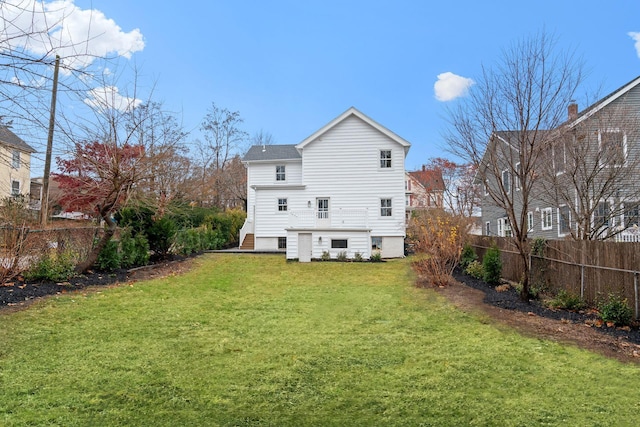 back of property with fence and a lawn