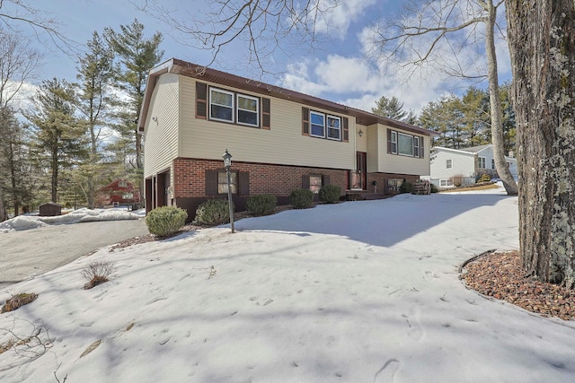 split foyer home featuring a garage and brick siding