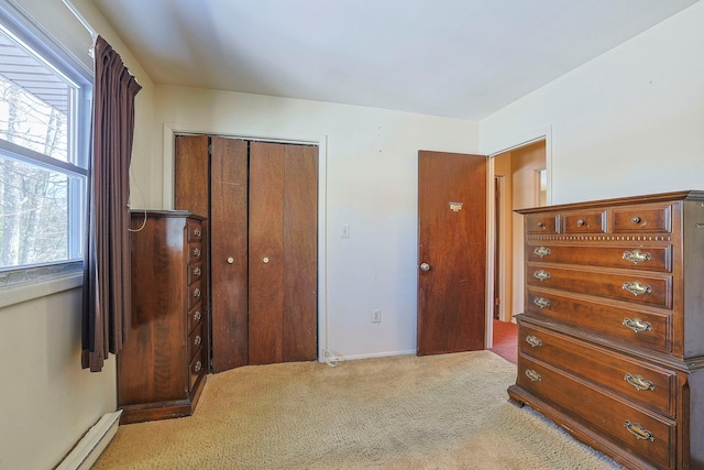 bedroom featuring carpet floors, baseboard heating, and a closet