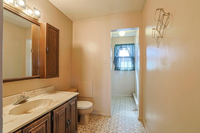 bathroom featuring baseboards, vanity, toilet, and tile patterned floors