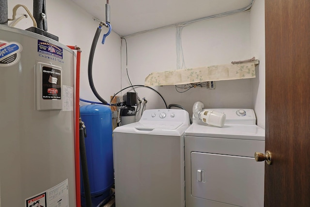 laundry room with laundry area, washing machine and clothes dryer, and electric water heater