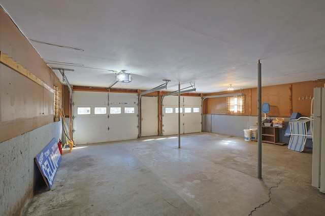 garage featuring a garage door opener and freestanding refrigerator