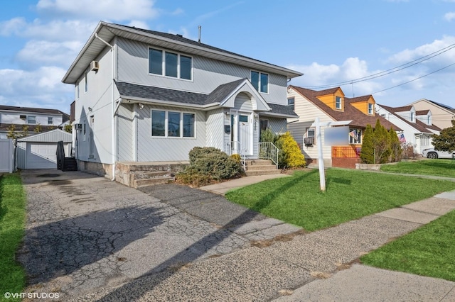 view of front of home with an outbuilding, a garage, and a front yard