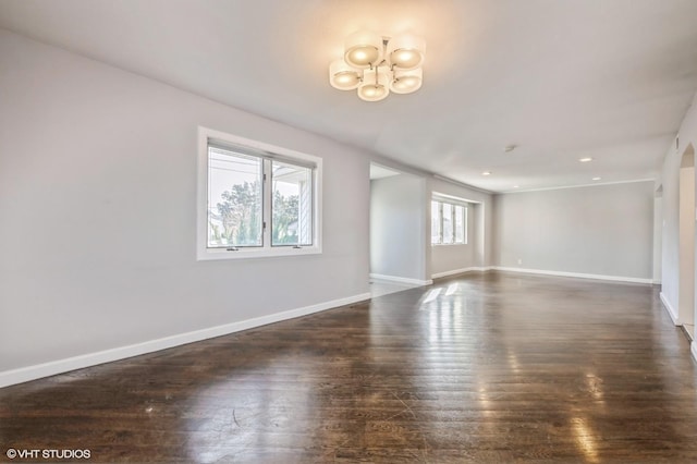 unfurnished room with dark hardwood / wood-style flooring and a notable chandelier