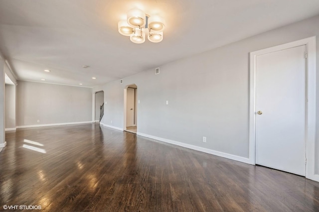 unfurnished room featuring dark hardwood / wood-style floors and a notable chandelier