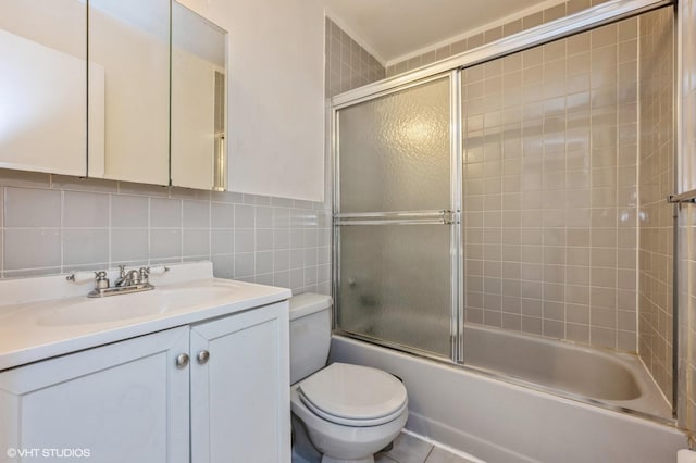 full bathroom with tasteful backsplash, enclosed tub / shower combo, toilet, vanity, and tile walls