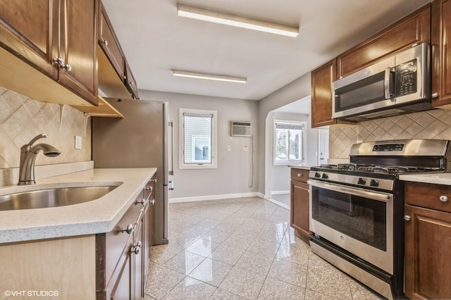 kitchen featuring a wall mounted air conditioner, decorative backsplash, sink, and stainless steel appliances