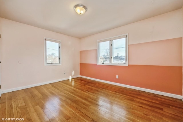 spare room with a healthy amount of sunlight and wood-type flooring