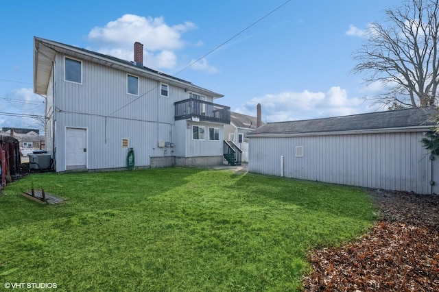 back of property with a yard, a balcony, and central AC unit