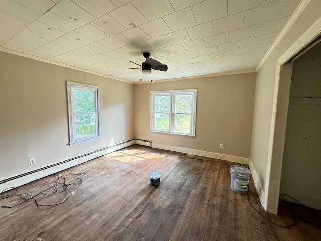 spare room featuring ceiling fan, plenty of natural light, wood-type flooring, and a baseboard radiator