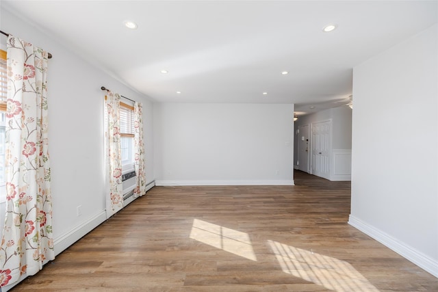 unfurnished living room featuring light hardwood / wood-style flooring and baseboard heating