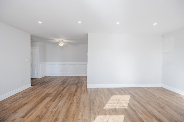 empty room with ceiling fan and light hardwood / wood-style floors