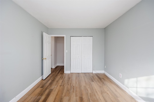 unfurnished bedroom with hardwood / wood-style floors and a closet