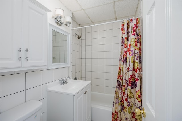 full bathroom featuring backsplash, a drop ceiling, shower / bath combo with shower curtain, tile walls, and toilet