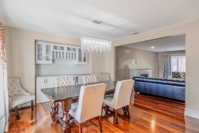 dining area with a notable chandelier and dark wood-type flooring