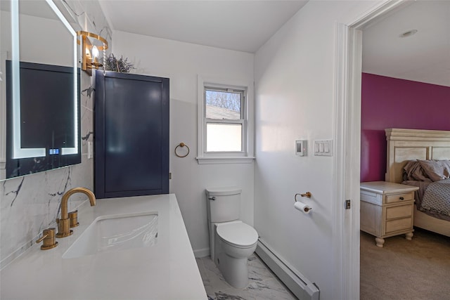 bathroom featuring vanity, a baseboard heating unit, and toilet