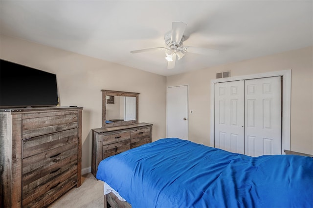 bedroom with ceiling fan, light colored carpet, and a closet