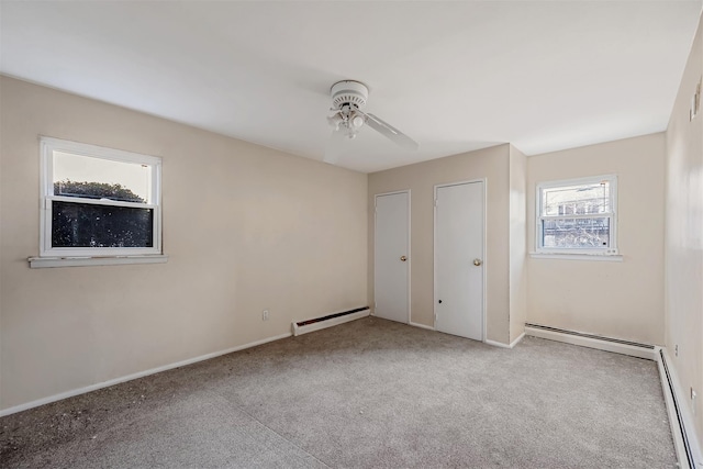 unfurnished bedroom with two closets, light colored carpet, ceiling fan, and baseboard heating