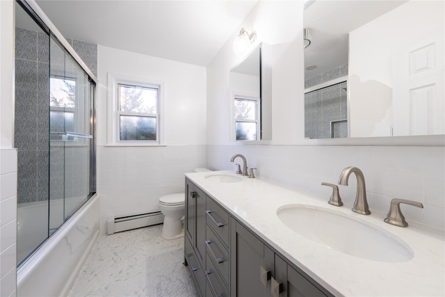 full bathroom featuring toilet, shower / bath combination with glass door, tile walls, vanity, and a baseboard heating unit