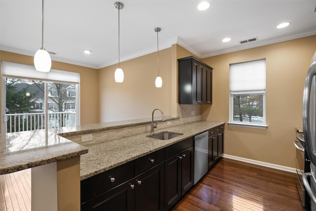 kitchen with light stone countertops, kitchen peninsula, stainless steel appliances, sink, and hanging light fixtures