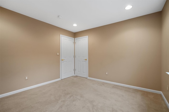 unfurnished room featuring recessed lighting, light carpet, and baseboards