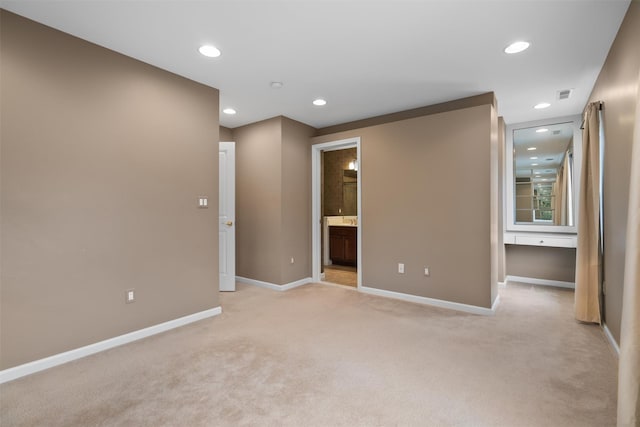 spare room with recessed lighting, light carpet, visible vents, and baseboards