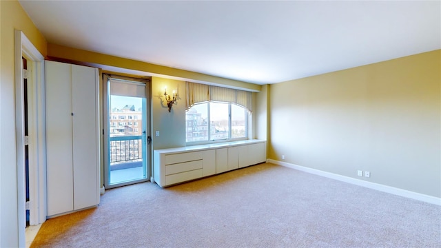 unfurnished bedroom featuring access to exterior and light colored carpet