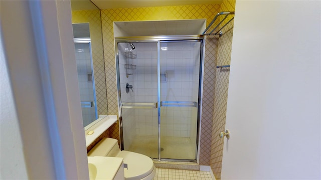 bathroom featuring vanity, toilet, and a shower with shower door