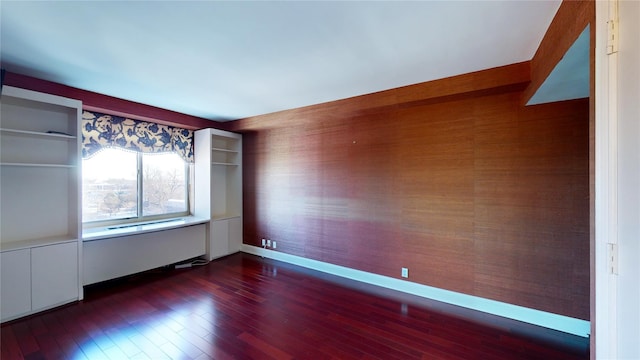 unfurnished room featuring dark hardwood / wood-style flooring and radiator