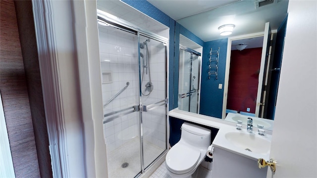 bathroom featuring vanity, a shower with shower door, and toilet