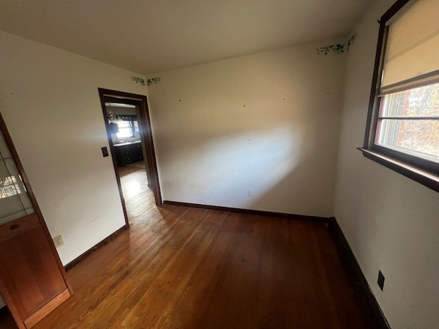 spare room with plenty of natural light and hardwood / wood-style floors