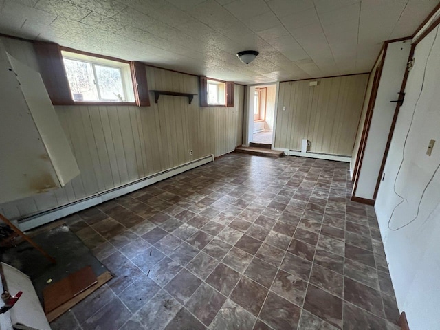 basement with baseboard heating and wood walls