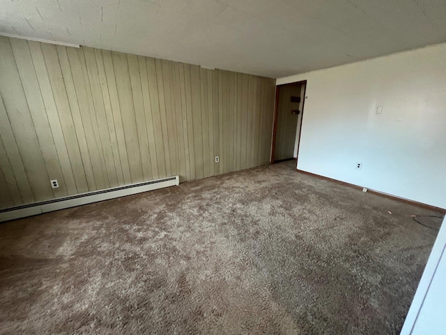 spare room with carpet and a baseboard heating unit