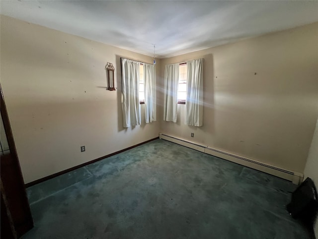 carpeted spare room with a baseboard heating unit