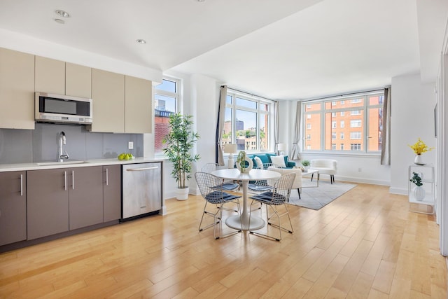 kitchen with stainless steel appliances, light hardwood / wood-style flooring, gray cabinetry, and sink