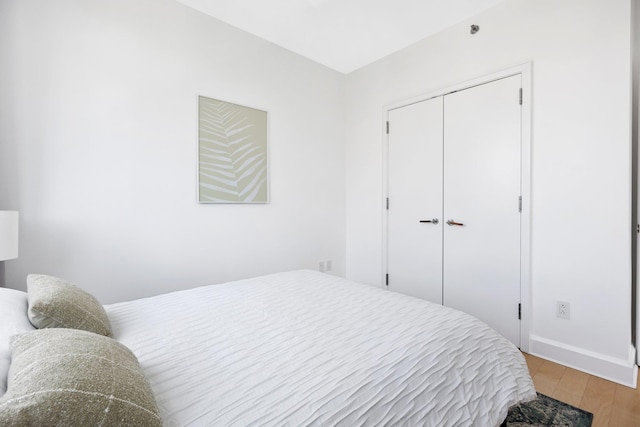 bedroom with light hardwood / wood-style floors and a closet