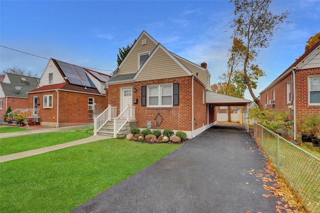 view of front of home with a carport, solar panels, and a front lawn