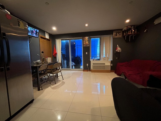 living room featuring an AC wall unit and light tile patterned floors