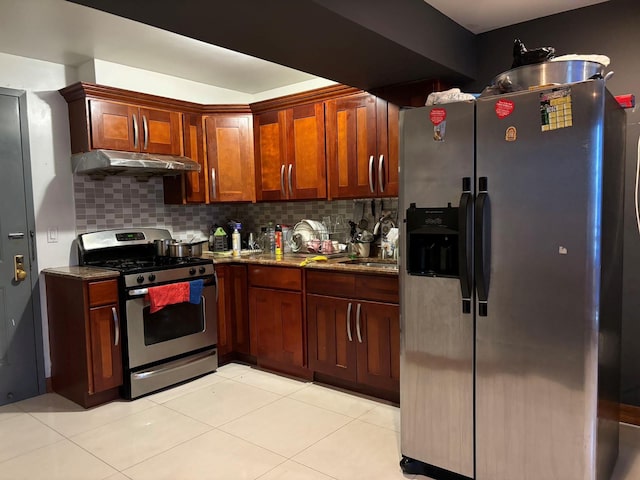 kitchen with backsplash, dark stone countertops, light tile patterned floors, and appliances with stainless steel finishes