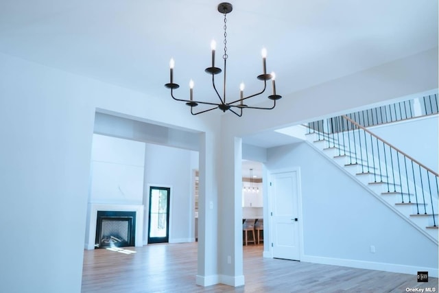 unfurnished living room featuring hardwood / wood-style floors and a notable chandelier