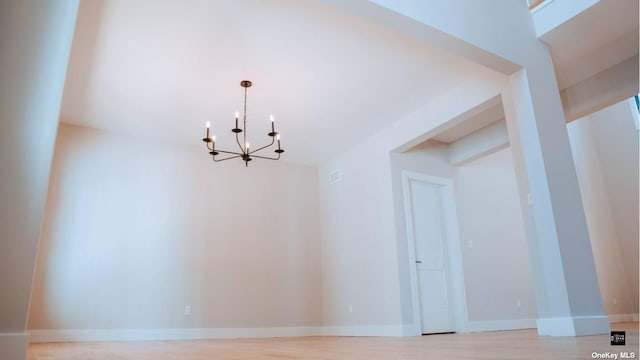 unfurnished dining area with light hardwood / wood-style flooring and an inviting chandelier