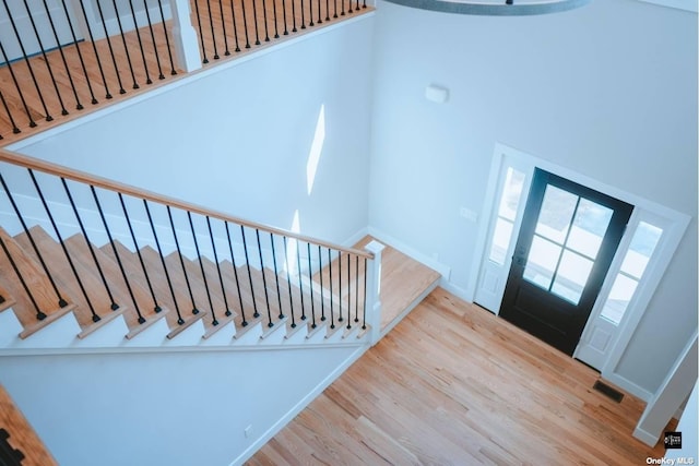 foyer with a towering ceiling and light hardwood / wood-style flooring