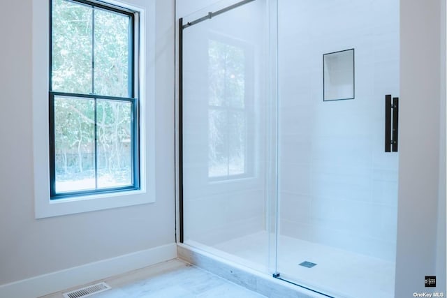 bathroom with a shower with door