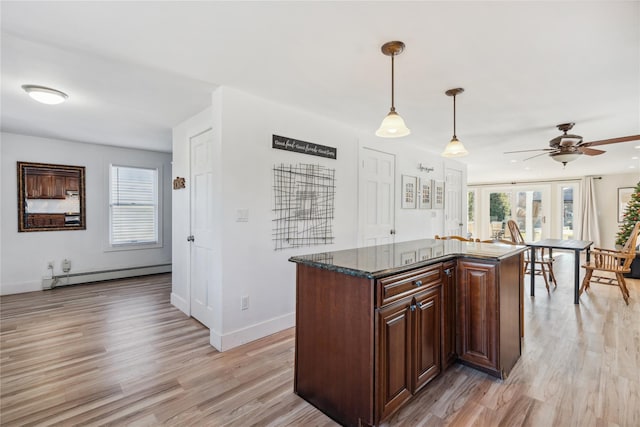 kitchen featuring ceiling fan, plenty of natural light, a baseboard radiator, and decorative light fixtures