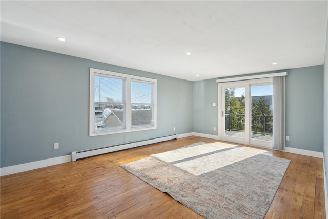 empty room with light hardwood / wood-style flooring and baseboard heating